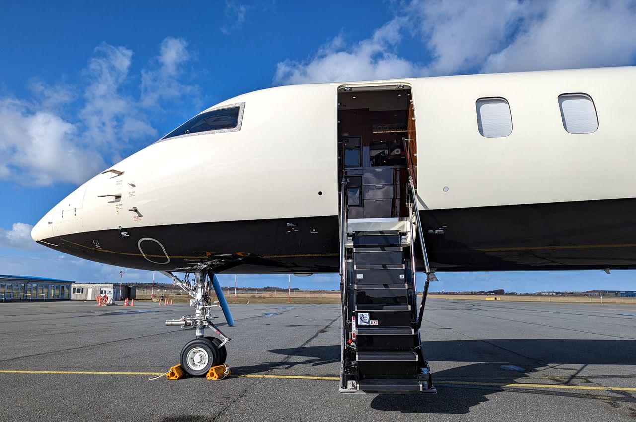 Crafting Captivating Headlines: Your awesome post title goes here A private jet with an open door, parked on an airport ramp under a clear blue sky.
