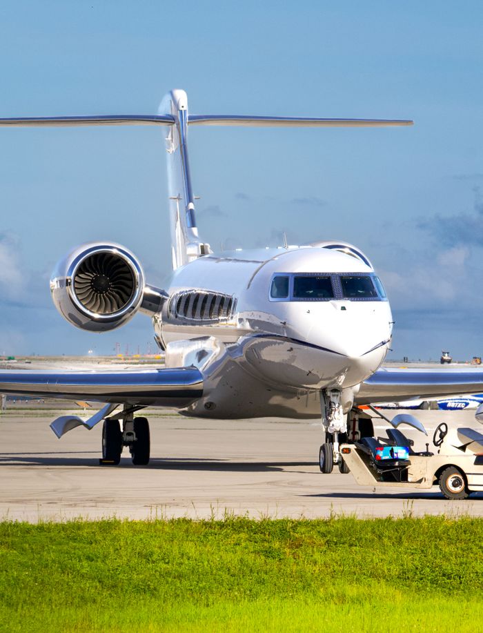 Services A sleek private jet being prepared for takeoff at the airport runway.